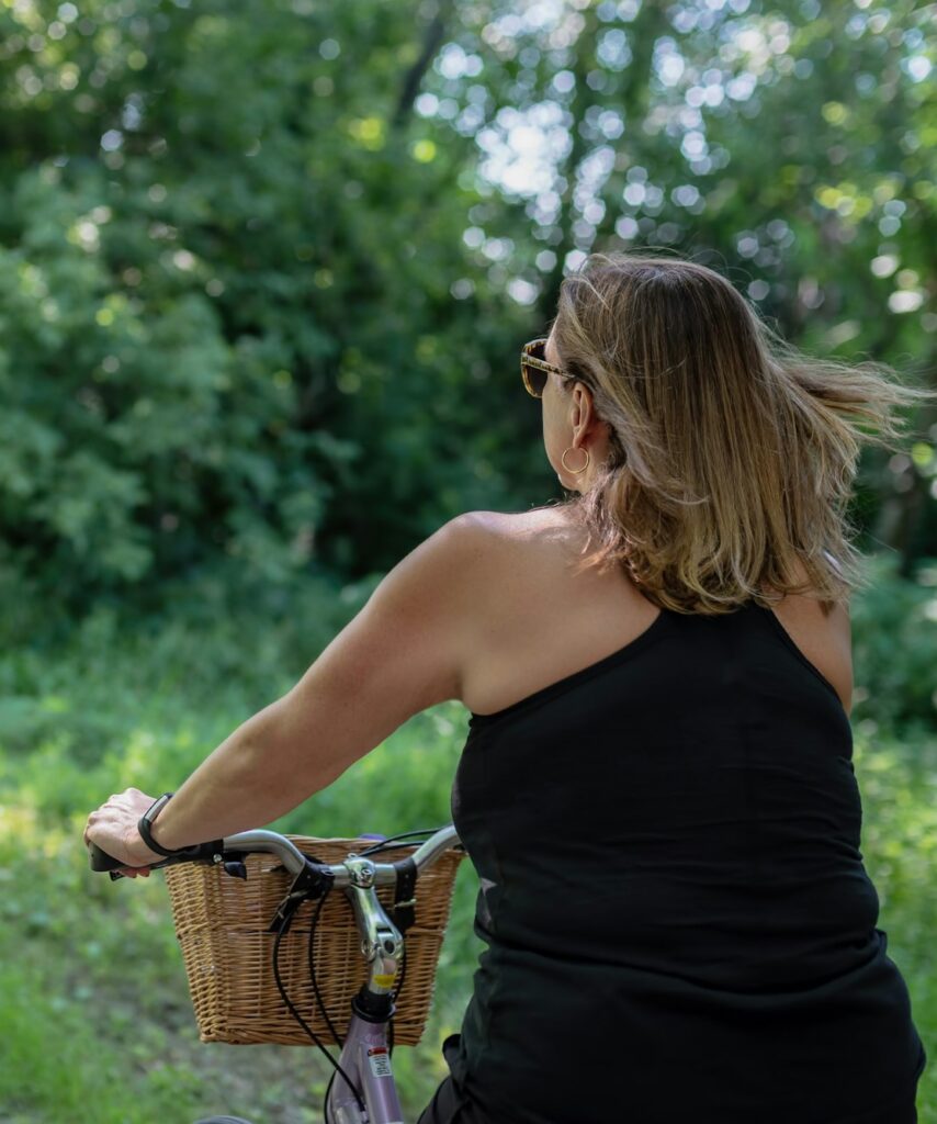 Woman riding bike through woods