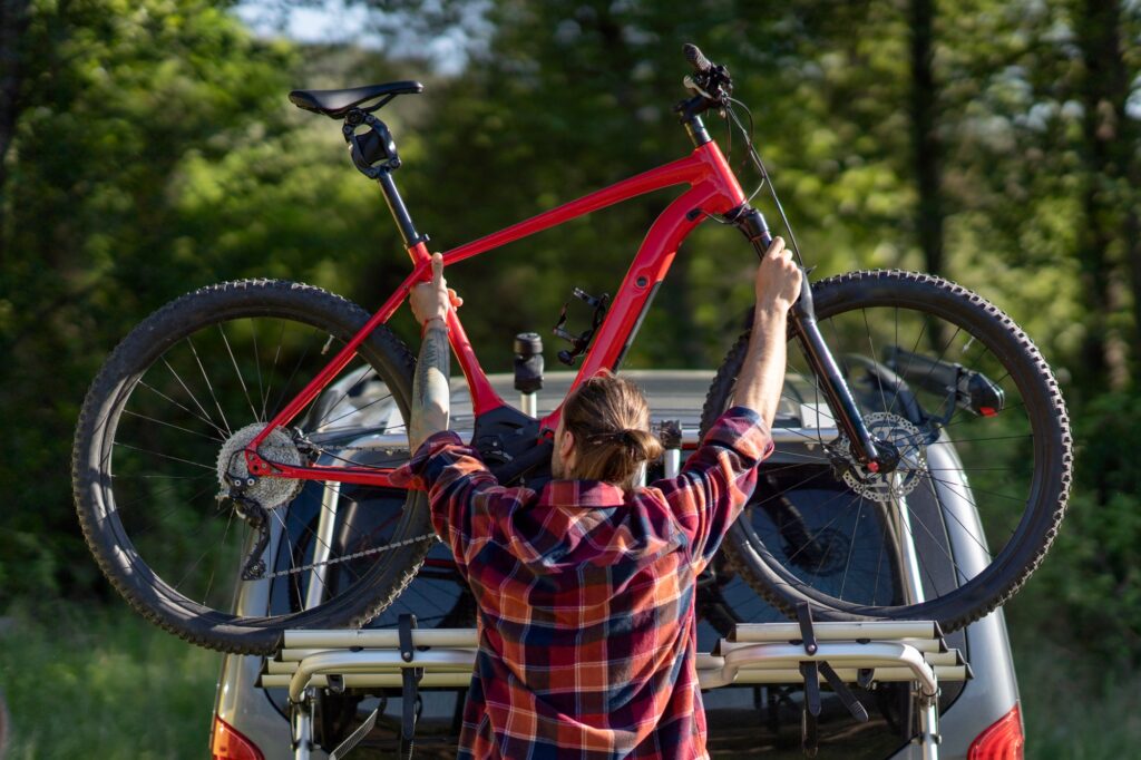 Man fastens bike on car stand